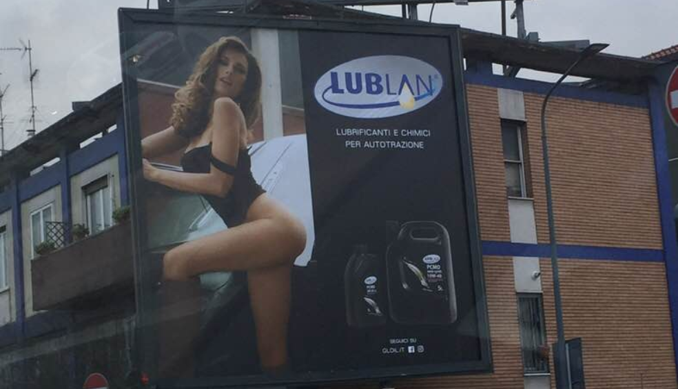 L’olio per motori con ragazza in lingerie: è polemica sul cartellone pubblicitario